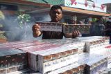 Petugas menunjukkan barang bukti rokok ilegal sebelum dimusnahkan di Kejaksaan Negeri Kabupaten Jombang, Jawa Timur, Kamis (17/7/2025). Kejari Jombang memusnahkan berbagai barang bukti tindak pidana diantaranya narkotika jenis sabu seberat 610,5 gram dari 54 perkara, pil double L sebanyak 613 butir dari 24 perkara, rokok tanpa pita cukai dari berbagai merek sebanyak 1.400 slop dari 45 perkara yang telah berkekuatan hukum tetap pada periode Maret hingga Juli 2025. Antara Jatim/Syaiful Arif/um