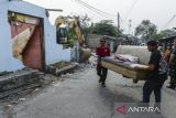 Warga mengangkut kursi sofa saat pembongkaran bangunan liar di Pasar Kemis, Kabupaten Tangerang, Banten, Kamis (17/7/2025). Pembongkaran belasan bangunan yang diduga digunakan sebagai tempat praktik prostitusi tersebut untuk menjaga kondusifitas lingkungan dan memberantas penyakit masyarakat. ANTARA FOTO/Putra M. Akbar/gp