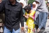 Seorang tersangka menangis saat digiring untuk dihadirkan pada rilis pengungkapan kasus perdagangan manusia dengan korban bayi di di Mapolda Jawa Barat, Bandung, Jawa Barat, Kamis (17/7/2025). Ditreskrimum Polda Jawa Barat menangkap 13 tersangka anggota sindikat yang bermarkas di Pontianak, Kalimantan Barat dalam kasus tindak pidana perdagangan orang (TPPO) jaringan internasional dengan memperdagangkan sedikitnya 25 bayi melalui modus adopsi secara ilegal ke Singapura. ANTARA FOTO/Novrian Arbi/agr