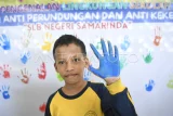 Seorang siswa penyandang disabilitas menunjukkan tangannya yang telah dilumuri cat air saat mengikuti deklarasi anti perundungan dan kekerasan dalam pelaksanaan Masa Pengenalan Lingkungan Sekolah (MPLS) di SLB Negeri Samarinda, Kalimantan Timur, Rabu (16/7/2025). Deklarasi tersebut bertujuan untuk menciptakan sekolah yang ramah anak yang terhindar dari perundungan, kekerasan serta dapat belajar dengan aman dan nyaman sehingga terbentuk anak yang berkarakter, bermartabat, dan bermanfaat. Antara Kaltim/M Risyal Hidayat/YU