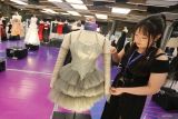 Panitia merapikan salah satu busana karya mahasiswa Universitas Kristen Petra (UKP) yang dipamerkan saat Innofashion Show 7 bertema Illumine di Surabaya, Jawa Timur, Kamis (17/7/2025). Kegiatan yang menampilkan 25 koleksi busana karya mahasiswa jurusan Textile and Fashion Design (DFT) UKP tersebut menjadi ajang bagi desainer muda untuk mengasah kreativitas dan mengeksplorasi keunikan dan ketertarikan mereka pada berbagai aspek fesyen dengan memanfaatkan kain tradisional menjadi karya busana yang modern. ANTARA Jatim/Moch Asim.