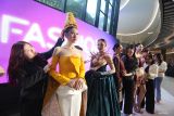 Sejumlah mahasiswa Universitas Kristen Petra (UKP)  menyiapkan model sebelum peragaan busana Innofashion Show 7 bertema Illumine di Surabaya, Jawa Timur, Kamis (17/7/2025). Kegiatan yang menampilkan 25 koleksi busana karya mahasiswa jurusan Textile and Fashion Design (DFT) UKP tersebut menjadi ajang bagi desainer muda untuk mengasah kreativitas dan mengeksplorasi keunikan dan ketertarikan mereka pada berbagai aspek fesyen dengan memanfaatkan kain tradisional menjadi karya busana yang modern. ANTARA Jatim/Moch Asim.