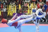 Taekwondoin DJA Bekangdam Elia Shallom (kanan) melakukan tendangan ke arah taekwondoin Manakara M. Ilham (kiri) dalam kualifikasi Kyorugi kelas Junior under 45 kilogram Kejuaraan Taekwondo Internasional 2025 di GOR Segiri, Samarinda, Kalimantan Timur, Kamis (17/7/2025). Kejuaraan taekwondo bertajuk 2nd East Borneo International Championship 2025 diikuti 920 atlet dari 15 provinsi serta dari Malaysia, Filipina, dan Korea Selatan. Antara Kaltim/M Risyal Hidayat/tom. 