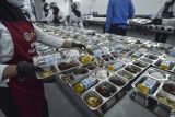 Petugas menyiapkan paket makanan saat uji coba pelaksanaan program Makan Bergizi Gratis (MBG) di dapur Satuan Pelayanan Pemenuhan Gizi (SPPG) Polda Jambi, Jambi, Kamis (17/7/2025). Kegiatan tersebut bertujuan memastikan kesiapan dapur SPPG Polda Jambi dalam melaksanakan program MBG usai diresmikan Kapolri secara serentak bersama 27 SPPG lain di tanah air. ANTARA FOTO/Wahdi Septiawan/agr