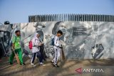 Pelajar berjalan untuk mengikuti aksi ekologi di Taman Monumen Perjuangan, Bandung, Jawa Barat, Jumat (18/7/2025). Pemerintah Provinsi Jawa Barat bekerja sama dengan Pandawara Group menggelar Aksi Ekologi dengan melakukan bersih-bersih beberapa taman di Kota Bandung di akhir Masa Pengenalan Lingkungan Sekolah (MPLS) yang diikuti oleh sekitar 30.000 pelajar SD, SMP, SMA. ANTARA FOTO/Raisan Al Farisi/agr