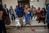 Warga membawa beras saat pendistribusian bantuan cadangan pangan di Kelurahan Cihapit, Bandung, Jawa Barat, Jumat (18/7/2025). Pemerintah Kota Bandung menyalurkan bantuan cadangan pangan dari Badan Pangan Nasional (Bapanas) berupa 10 kilogram beras kepada 85.167 warga di 151 yang ada kelurahan di Kota Bandung. ANTARA FOTO/Raisan Al Farisi/agr