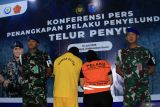 KKP tangkap penyelundup telur penyu di Kalbar. Dua petugas Pomdam XII/Tanjungpura bersiaga di samping dua tersangka penyelundupan telur penyu yang dihadirkan dalam konferensi pers di Stasiun PSDKP Pontianak, Sungai Rengas, Kabupaten Kubu Raya, Kalimantan Barat, Jumat (18/7/2025). Kementerian Kelautan dan Perikanan (KKP) menangkap dua pelaku penyelundupan 5.400 butir telur penyu di Pelabuhan Sintete, Kabupaten Sambas, Kalimantan Barat pada pekan lalu, yakni seorang personel aktif TNI AD berinisial SD dan seorang warga sipil berinisial MU, yang terindikasi terhubung dengan jaringan perdagangan ilegal internasional di Malaysia. ANTARA FOTO/Jessica Wuysang/bar