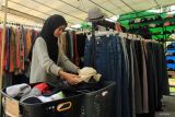 Seorang pedagang merapikan barang dagangannya dalam Pameran UMKM yang digelar dalam rangka peringatan Hari Keluarga Bersama di Pendopo Gubernur Kalbar, Pontianak, Kalimantan Barat, Sabtu (19/7/2025). Dinas Koperasi, Usaha Kecil dan Menengah Provinsi Kalimantan Barat mencatat sebanyak 164.364 UMKM telah masuk dalam Sistem Informasi Data Tunggal (SIDT), namun jutaan lainnya terutama usaha mikro belum terdata sehingga pendataan terus digencarkan secara masif. ANTARA FOTO/Jessica Wuysang/nz