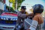 Petugas kepolisian membenahi cara penggunaan helm pengendara sepeda motor saat Operasi Patuh Semeru di Lumajang, Jawa Timur, Senin (21/7/2025). Satlantas Polres Lumajang bersama Dinas Perhubungan (Dishub) Lumajang melakukan Operasi Patuh Semeru dalam rangka meningkatkan kesadaran dan kepatuhan berlalu lintas dengan pendekatan persuasif, edukatif, juga humanis dengan harapan dapat meminimalisasi tingkat kecelakaan di wilayah tersebut. Antara Jatim/Irfan Sumanjaya/um 