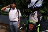 Polisi menghukum pengendara dibawah umur dengan menyanyikan lagu Indonesia Raya usai terjaring Operasi Patuh Lodaya 2025 di Simpang PDAM, Cibinong, Kabupaten Bogor, Jawa Barat, Selasa (15/7/2025). Polres Bogor menggelar Operasi Patuh Lodaya 2025 selama dua pekan mulai 14-27 Juli 2025, operasi itu dilaksanakan dengan dua metode penindakan, yaitu tilang manual dan sistem Electronic Traffic Law Enforcement (ETLE) dengan sasaran tujuh pelanggaran diantaranya tidak memakai helm, melawan arus serta pengendara dibawah umur. ANTARA FOTO/Yulius Satria Wijaya/bar 