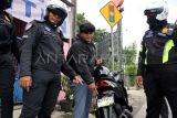 Polisi menilang pengendara yang menggunakan plat nomad kendaraan modifikasi saat Operasi Patuh Lodaya 2025 di Simpang PDAM, Cibinong, Kabupaten Bogor, Jawa Barat, Selasa (15/7/2025). Polres Bogor menggelar Operasi Patuh Lodaya 2025 selama dua pekan mulai 14-27 Juli 2025, operasi itu dilaksanakan dengan dua metode penindakan, yaitu tilang manual dan sistem Electronic Traffic Law Enforcement (ETLE) dengan sasaran tujuh pelanggaran diantaranya tidak memakai helm, melawan arus serta pengendara dibawah umur. ANTARA FOTO/Yulius Satria Wijaya/bar 