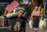 Warga memikul beras saat penyaluran bantuan pangan di Cibodas, Kota Tangerang, Banten, Selasa (22/7/2025). Perum Bulog menargetkan penyaluran bantuan pangan periode Juni-Juli 2025 sebesar 365.541.660 kilogram untuk 18,3 juta keluarga penerima manfaat sebagai bagian dari stimulus ekonomi kuartal II 2025. ANTARA FOTO/Putra M. Akbar/gp