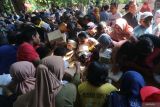 Warga berebut nasi kotak yang telah diberi doa saat tradisi ziarah Punden Prabu Anom di Desa Doko, Kabupaten Kediri, Jawa Timur, Selasa (22/7/2025). Tradisi ziarah di punden putra Raja Kediri Sri Aji Jayabaya tersebut menjadi agenda wisata budaya Kediri setiap bulan Suro penanggalan Jawa. ANTARA Jatim/Prasetia Fauzani/mas.