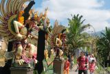 Wisatawan mancanegara mengamati patung berbahan anyaman bambu saat berkunjung di Desa Wisata Jatiluwih, Tabanan, Bali, Minggu (20/7/2025). Kementerian Pariwisata pada periode Januari-Mei 2025 mencatat kunjungan wisatawan mancanegara ke Indonesia sebanyak 5,63 juta orang yaitu lebih tinggi dibandingkan perjalanan wisatawan Indonesia ke luar negeri sebanyak 3,84 juta orang. ANTARA FOTO/Nyoman Hendra Wibowo/wsj.