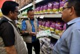 Petugas Satgas Pangan Polri memeriksa beras premium kemasan saat sidak beras oplosan di Lotte Mart, Kota Bogor, Jawa Barat, Selasa (22/7/2025). Sidak yang dilakukan Satgas Pangan Polri bersama Bapanas dan Dinas Koperasi, UKM, Perdagangan dan Perindustrian Kota Bogor tersebut untuk memastikan tidak ada beras oplosan yang dijual oleh pedagang maupun agen distributor. ANTARA FOTO/Arif Firmansyah/tom. 