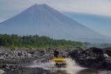 Wisatawan melintasi kubangan air menggunakan mobil jip saat mengunjungi Desa Wisata Sumberurip, Kecamatan Pronojiwo, Lumajang, Jawa Timur, Rabu (23/7/2025). Desa di kaki Gunung Semeru yang memiliki sejumlah potensi wisata dengan perpaduan pemandangan alam dan gunung tersebut dimanfaatkan oleh warga setempat untuk memberikan paket perjalanan wisata seperti  jelajah desa dan susur aliran sungai menggunakan jip, lokasi berkemah, agrowisata juga sajian hidangan kuliner khas setempat. Antara Jatim/Irfan Sumanjaya/um