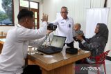 Kepala Kantor Wilayah Direktorat Jenderal Imigrasi Aceh Tato Juliadin Hidayawan (tengah) memantau pelaksanaan program pengurusan paspor sembari ngopi (pasbro) di warung Sidiq kopi, Banda Aceh, Aceh Rabu (23/7/2025). Program bulanan jemput bola pasbro yang dilaksanakan kantor imigrasi kota Banda Aceh itu sebagai upaya memberikan pelayanan kepada warga untuk pembuatan dan perpanjangan paspor. Antara Aceh/Irwansyah Putra.