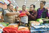 Direktur Reskrimsus Polda Bali Kombes Pol. Teguh Widodo (kiri) bersama Kadis Pertanian dan Ketahanan Pangan Bali I Wayan Sunada (kedua kanan) memeriksa beras premium yang dijual di pusat perbelanjaan di wilayah Denpasar, Bali, Selasa (22/7/2025). Sidak tersebut dilakukan untuk memastikan tidak ada praktik pengoplosan dan kecurangan penjualan beras seperti beras oplosan yang dijual dengan label premium serta beras yang tidak sesuai dengan takaran. ANTARA FOTO/Fikri Yusuf/wsj.