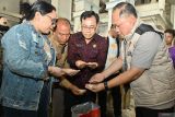 Direktur Reskrimsus Polda Bali Kombes Pol. Teguh Widodo (kanan) bersama Kadis Pertanian dan Ketahanan Pangan Bali I Wayan Sunada (kedua kanan) memeriksa beras saat melakukan sidak peredaran beras oplosan di tempat penggilingan padi di wilayah Denpasar, Bali, Selasa (22/7/2025). Sidak tersebut dilakukan untuk memastikan tidak ada praktik pengoplosan dan kecurangan penjualan beras seperti beras oplosan yang dijual dengan label premium serta beras yang tidak sesuai dengan takaran. ANTARA FOTO/Fikri Yusuf/wsj.