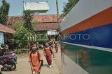 Sejumlah siswa SDN Burangkeng 04 berjalan sepulang sekolah di samping proyek pembangunan Jalan Tol Jakarta-Cikampek seksi II di Setu, Kabupaten Bekasi, Jawa Barat, Selasa (22/7/2025).Menurut keterangan guru, orang tua murid mengeluhkan lokasi bangunan sekolah yang belum direlokasi ke tempat yang baru dan berdampak pada penurunan minat murid baru yang mendaftar ke sekolah tersebut pada tahun ajaran 2025/2026 yang hanya mendapatkan 47 murid. ANTARA FOTO/ Fakhri Hermansyah/rwa. 