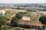 Foto udara bangunan SDN Burangkeng 04 yang terletak di dekak proyek Jalan Tol Jakarta-Cikampek seksi II di Setu, Kabupaten Bekasi, Jawa Barat, Selasa (22/7/2025). Menurut keterangan guru, orang tua murid mengeluhkan lokasi bangunan sekolah yang belum direlokasi ke tempat yang baru dan berdampak pada penurunan minat murid baru yang mendaftar ke sekolah tersebut pada tahun ajaran 2025/2026 yang hanya mendapatkan 47 murid. ANTARA FOTO/ Fakhri Hermansyah/rwa. 