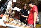 Anggota komunitas menjelaskan bagian keris kepada salah satu pengunjung dalam Festival Tong-tong Market di Malang, Jawa Timur, Kamis (24/7/2025). Festival yang merupakan bagian dari Karisma Event Nusantara (KEN) itu digelar selama empat hari untuk memperkenalkan budaya lokal serta mendorong geliat ekonomi kreatif melalui berbagai stan pameran antara lain cinema Indonesia, keris, permainan tradisional serta Usaha Mikro Kecil Menangah (UMKM). Antara Jatim/Ari Bowo Sucipto/um