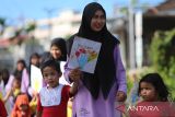 Murid Pendidikan Anak Usia Dini (PAUD) dan murid Taman Kanak kanak (TK) bersama gurunya membawa poster berjalan kaki saat menggelar karnaval  di lingkungan Sekolah Harsya Ceria, Banda Aceh, Aceh, Kamis (24/7/2025). Sekolah Harsya Ceria yang merupakan sekolah inklusi perpaduan pendidikan reguler dan pendidikan anak berkebutuhan khusus di daerah itu  memperingati Hari Anak Nasional (HAN)  dengan kegiatan karnaval membawa poster  yang bertuliskan ,  Anak Rajin, Anak Hebat, Anak Disiplin  dan Anak Ceria untuk Indonesia Kuat Menuju Indonesia Emas. ANTARA FOTO/Ampelsa.