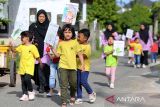 Murid Pendidikan Anak Usia Dini (PAUD) dan murid Taman Kanak kanak (TK) bersama gurunya membawa poster berjalan kaki saat menggelar karnaval  di lingkungan Sekolah Harsya Ceria, Banda Aceh, Aceh, Kamis (24/7/2025). Sekolah Harsya Ceria yang merupakan sekolah inklusi perpaduan pendidikan reguler dan pendidikan anak berkebutuhan khusus di daerah itu  memperingati Hari Anak Nasional (HAN)  dengan kegiatan karnaval membawa poster  yang bertuliskan ,  Anak Rajin, Anak Hebat, Anak Disiplin  dan Anak Ceria untuk Indonesia Kuat Menuju Indonesia Emas. ANTARA FOTO/Ampelsa.