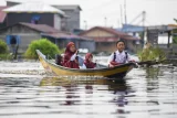Tiga orang pelajar menaiki perahu saat akan menuju ke sekolahnya di Desa Muara Enggelam, Muara Wis, Kutai Kartanegara, Kalimantan Timur, Rabu (23/7/2025). Mendikdasmen Abdul Mu'ti memaparkan tiga strategi utama untuk mewujudkan pendidikan yang merata, tanpa kesenjangan akses yakni metode Pembelajaran Jarak Jauh (PJJ) untuk anak-anak yang memiliki keterbatasan geografis, pendidikan kesetaraan melalui berbagai Pusat Kegiatan Belajar Masyarakat (PKBM) dan pembangunan sekolah satu atap yaitu satu bangunan sekolah memiliki dua atau tiga jenjang pendidikan. Antara Kaltim/M Risyal Hidayat