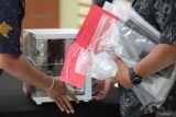 Polisi membawa barang bukti saat rilis kasus penempatan pekerja migran Indonesia secara ilegal di Polda Jawa Timur, Surabaya, Jawa Timur, Jumat (25/7/2025). Ditreskrimum Polda Jawa Timur menangkap seorang tersangka berinisial TGS (49) atas kasus dugaan merekrut dan menempatkan CPMI (Calon Pekerja Migran Indonesia) untuk ditempatkan di negara Jerman secara ilegal dengan korbannya berinisial WA, TW serta PCY . ANTARA Jatim/Didik Suhartono/mas.