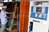 Petugas menata beras premium kemasan di samping mesin pompa minyak goreng Koperasi Kelurahan Merah Putih di Kelurahan Curug Mekar, Kota Bogor, Jawa Barat, Rabu (23/7/2025). Koperasi Kelurahan Merah Putih tersebut menyediakan barang kebutuhan pokok dan berinovasi menjual minyak goreng curah seharga Rp15.500 per liter menggunakan pom minyak goreng curah berkapasitas 150 liter. ANTARA FOTO/Arif Firmansyah/rwa. 