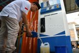 Petugas menata beras premium kemasan di samping mesin pompa minyak goreng Koperasi Kelurahan Merah Putih di Kelurahan Curug Mekar, Kota Bogor, Jawa Barat, Rabu (23/7/2025). Koperasi Kelurahan Merah Putih tersebut menyediakan barang kebutuhan pokok dan berinovasi menjual minyak goreng curah seharga Rp15.500 per liter menggunakan pom minyak goreng curah berkapasitas 150 liter. ANTARA FOTO/Arif Firmansyah/rwa. 
