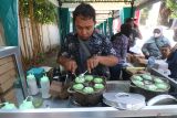 Seorang pedagang menyelesaikan pembuatan kue bikang saat Festival Jajanan Pasar di Kota Kediri, Jawa Timur, Minggu (27/7/2025).  Festival Jajanan Pasar yang diselenggrakan pemerintah daerah setempat tersebut diikuti oleh 50 pedagang sebagai upaya menggerakkan ekonomi masyarakat kecil sekaligus melestarikan makanan tradisional sehat tanpa pengawet. ANTARA Jatim/Prasetia Fauzani/mas.
