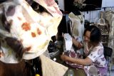 Perajin Cecilia Triputri Wardhani menjahit busana ecoprint di rumah produksi Trilogi Ecoprint, Pandanwangi, Malang, Jawa Timur, Selasa (29/7/2025). Perajin tersebut berinovasi dengan memanfaatkan keanekaragaman hayati tanaman lokal seperti daun jati dan waru sebagai motif ciri khas serta mengembangkan kerajinan tas dari limbah plastik dengan mengusung konsep berkelanjutan (sustainable), sederhana dan siap pakai yang kemudian dipasarkan lewat media sosial hingga menembus pasar Australia, Portugal, dan berbagai kota di Indonesia, dengan harga Rp75 ribu hingga Rp400 ribu menurut jenis produk. Antara Jatim/Ari Bowo Sucipto/um