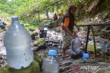 Warga mengisi galon dengan air di Gunung Batur, Kota Cilegon, Banten, Selasa (29/7/2025). Warga setempat kesulitan mendapatkan air bersih sejak sepekan terakhir karena musim kemarau sehingga terpaksa berjalan kaki sekitar satu kilometer dari permukiman kampung untuk mendapatkan sumber mata air di Gunung Batur guna memenuhi kebutuhan air sehari-hari. ANTARA FOTO/Muhammad Bagus Khoirunas/gp
