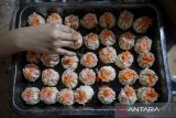 Pekerja menaburkan irisan wortel ke adonan dimsum di Griya Dimsum Bunda Imoet, Ciputat, Kota Tangerang Selatan, Banten, Rabu (30/7/2025). Kementerian Usaha Mikro Kecil dan Menengah (UMKM) menyatakan hingga semester I-2025 sebanyak satu juta dari target 1,2 juta UMKM naik kelas dari level usaha mikro ke kecil dan dari usaha kecil ke menengah berkat program Kredit Usaha Rakyat (KUR) yang memberi dampak positif dalam mendukung perekonomian rakyat. ANTARA FOTO/Putra M. Akbar/gp