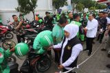 Gubernur Jawa Timur Khofifah Indar Parawansa (ketiga kanan didampingi Bupati Jember Muhammad Fawait (kedua kanan) bersalaman dengan pengemudi ojol saat meninjau SPBU Mangli, Jember, Jawa Timur, Kamis (31/7/2025). Peninjauan tersebut guna memastikan pasokan dan stok BBM di Kabupaten Jember normal dan tercukupi usai mengalami kelangkaan akibat penutupan jalur Gumitir, Banyuwangi pada Kamis (24/7/2025). ANTARA Jatim/Moch Asim.
