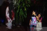 Warga berkostum hantu menakuti pengunjung yang datang di wisata Desa Hantu, Cicadas, Bandung, Jawa Barat, Jumat (1/8/2025). Warga kawasan tersebut merubah gang permukiman padat sepanjang 60 meter menjadi konsep desa hantu dengan berbagai jenis mitos hantu di Indonesia agar dikembangkan sebagai lokasi wisata ikonik bagi masyarakat Kota Bandung. ANTARA FOTO/Novrian Arbi/agr