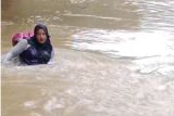 Viral, Seorang bidan nekat arungi sungai bertaruh nyawa untuk obati pasien di Pasaman (Video)
