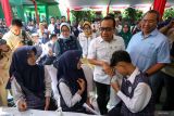 Menteri Koordinator Bidang Pembangunan Manusia dan Kebudayaan Pratikno (tengah) berbincang dengan siswa saat meninjau peluncuran program Cek Kesehatan Gratis (CKG) untuk anak sekolah di SMP Negeri 1 Padangan, Bojonegoro, Jawa Timur, Senin (4/8/2025). Peluncuran program CKG Sekolah dengan target sebanyak 53,8 juta siswa dari 282 ribu satuan pendidikan mulai dari SD, SMP, SMA di seluruh Indonesia yang digalakkan pemerintah itu bertujuan untuk mendorong deteksi dini penyakit dan meningkatkan kesadaran masyarakat terhadap pentingnya pemeriksaan kesehatan secara rutin khususnya bagi generasi muda guna mewujudkan generasi sehat menuju Indonesia Emas 2045. Antara Jatim/Muhammad Mada/um