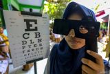 Siswi melakukan tes mata saat peluncuran program Cek Kesehatan Gratis (CKG) untuk anak sekolah di SMP Negeri 1 Padangan, Bojonegoro, Jawa Timur, Senin (4/8/2025). Peluncuran program CKG Sekolah dengan target sebanyak 53,8 juta siswa dari 282 ribu satuan pendidikan mulai dari SD, SMP, SMA di seluruh Indonesia yang digalakkan pemerintah itu bertujuan untuk mendorong deteksi dini penyakit dan meningkatkan kesadaran masyarakat terhadap pentingnya pemeriksaan kesehatan secara rutin khususnya bagi generasi muda guna mewujudkan generasi sehat menuju Indonesia Emas 2045. Antara Jatim/Muhammad Mada/um