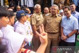 Menteri Kesehatan Budi Gunadi Sadikin (kanan) didampingi Wali Kota Bandung M. Farhan (kedua kanan) berdialog dengan pelajar sebelum meninjau pemeriksaan kesehatan gratis bagi anak sekolah di SMPN 5, Bandung, Jawa Barat, Senin (4/8/2025). Peninjauan tersebut guna memastikan pelaksanaan program cek kesehatan gratis bagi anak sekolah tepat sasaran guna menjalan UU No. 17 Tahun 2023 tentang kesehatan dan Program Hasil Terbaik Cerpat (PHCT) sehingga mewujudkan anak Indonesia sehat menuju generasi emas 2045. ANTARA FOTO/Novrian Arbi/agr