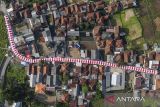 Foto udara bendera Merah Putih terbentang di Kampung Cibahong, Desa Sukamenak, Kecamatan Sukarame, Kabupaten Tasikmalaya, Jawa Barat, Rabu (6/8/2025). Kain merah putih yang menghiasi jalan perkampungan sepanjang 250 meter itu dikerjakan warga secara gotong royong selama tiga pekan dan menghabiskan anggaran Rp20 juta untuk memeriahkan HUT Ke-80 RI. ANTARA FOTO/Adeng Bustomi/agr
