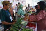 Petugas melayani pembeli di salah satu stan dalam Gebyar Pangan Murah di Dinas Ketahanan Pangan Kabupaten Tulungagung, Tulungagung, Jawa Timur, Rabu (6/8/2025). Kegiatan Gebyar Pangan Murah yang diikuti 49 perwakilan dinas/kecamatan dan UMKM itu digelar dengan tujuan mengendalikan laju inflasi daerah melalui penyediaan aneka kebutuhan pokok dengan harga sesuai HET (harga eceran tertinggi). Antara Jatim/Destyan Sujarwoko/um 