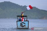 Komunitas Mancing Aceh menumpang perahu motor membawa bendera saat menuju Pulau Tuan, di desa Lamteungoh, kecamatan Peukan Bada, kabupaten Aceh Besar, Aceh, Minggu (10/8/2025). Pengibaran bendera di  Pulau Tuan yang memiliki keindahan wisata bawah laut ,terumbu karang dan berbagai jenis ikan hias di daerah tersebut  dalam rangka menyambut HUT ke 80 Republik Indonesia. ANTARA FOTO/Ampelsa.