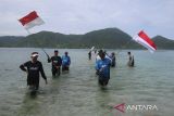 Komunitas Mancing Aceh berbaris membawa bendera untuk dikibarkan di perairan Pulau Tuan, desa Lamteungoh, kecamatan Peukan Bada, kabupaten Aceh Besar, Aceh, Minggu (10/8/2025). Pengibaran bendera di  Pulau Tuan yang memiliki keindahan wisata bawah laut ,terumbu karang dan berbagai jenis ikan hias di daerah tersebut  dalam rangka menyambut HUT ke 80 Republik Indonesia. ANTARA FOTO/Ampelsa.