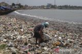 Warga mencari barang bekas bernilai jual pada tumpukan sampah di kawasan pesisir Desa Teluk, Labuan, Kabupaten Pandeglang, Banten, Senin (11/8/2025). Kementerian Kelautan dan Perikanan (KKP) mengupayakan untuk mengurangi volume sampah ke lautan melalui intervensi langsung di kawasan sungai, pesisir dan pulau kecil, serta pelabuhan dan wilayah aktivitas laut dengan menargetkan 70 persen sampah dapat dicegah masuk ke laut pada tahun 2029. ANTARA FOTO/Angga Budhiyanto/gp