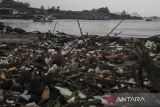 Perahu nelayan melintas di sekitar tumpukan sampah di kawasan pesisir Desa Sidamukti, Sukaresmi, Kabupaten Pandeglang, Banten, Senin (11/8/2025). Kementerian Kelautan dan Perikanan (KKP) mengupayakan untuk mengurangi volume sampah ke lautan melalui intervensi langsung di kawasan sungai, pesisir dan pulau kecil, serta pelabuhan dan wilayah aktivitas laut dengan menargetkan 70 persen sampah dapat dicegah masuk ke laut pada tahun 2029. ANTARA FOTO/Angga Budhiyanto/gp