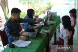 Petugas Disdukcapil Kota Pontianak merekam data pelajar SD untuk pembuatan Kartu Identitas Anak (KIA) dalam layanan jemput bola di Sekolah Dasar Negeri (SDN) 10 Pontianak Utara, Kalimantan Barat, Selasa (20/5/2025). Sebanyak 118.557 anak atau 63,45 persen dari total anak di Kota Pontianak telah memiliki Kartu Identitas Anak (KIA) melalui program Pelayanan Cetak Kartu Identitas Anak Sehari Jadi (PECI HAJI) yang menyasar anak usia sekolah dengan sistem jemput bola di sekolah maupun di ruang publik. ANTARA FOTO/Jessica Wuysang