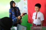 Kepala Disdukcapil Kota Pontianak Erma Suryani (tengah) menyaksikan proses perekaman data untuk pembuatan Kartu Identitas Anak (KIA) dalam layanan jemput bola di Sekolah Dasar Negeri (SDN) 10 Pontianak Utara, Kalimantan Barat, Selasa (20/5/2025). Sebanyak 118.557 anak atau 63,45 persen dari total anak di Kota Pontianak telah memiliki Kartu Identitas Anak (KIA) melalui program Pelayanan Cetak Kartu Identitas Anak Sehari Jadi (PECI HAJI) yang menyasar anak usia sekolah dengan sistem jemput bola di sekolah maupun di ruang publik. ANTARA FOTO/Jessica Wuysang